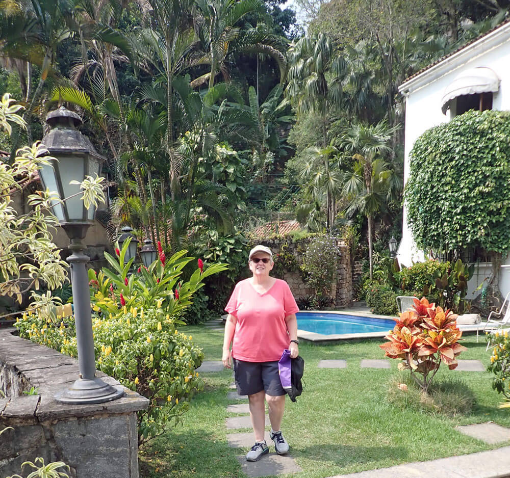 Sheila stands in garden area.